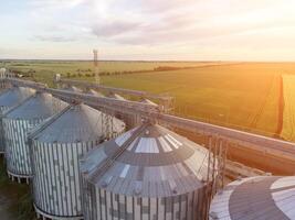 moderno metal silos em agroprocessamento e fabricação plantar. aéreo Visão do celeiro elevador em processamento secagem limpeza e armazenamento do agrícola produtos, farinha, cereais e grão. ninguém. foto