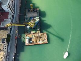 flutuando guindaste dragagem barcaças trabalhando em a construção do uma marina. aéreo topo Visão foto