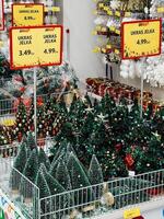 podgorica, Montenegro - 25 dezembro 2022. pequeno artificial decorado Natal árvores ficar de pé dentro uma supermercado foto