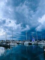 marina com Navegando iates e porta guindaste contra a crepúsculo céu foto