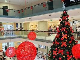 budva, Montenegro - 25 dezembro 2022. ampla decorado Natal árvore carrinhos dentro uma compras Centro entre pavimentos foto
