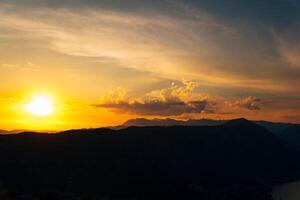 laranja pôr do sol dentro a céu sobre uma montanha alcance foto