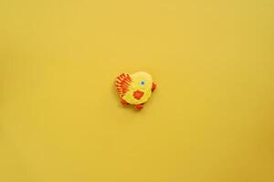 envidraçado amarelo Pão de gengibre frango mentiras em uma amarelo fundo foto