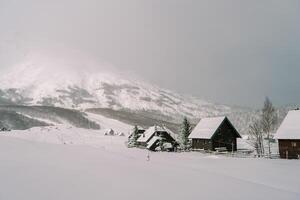 coberto de neve acolhedor Vila dentro uma montanha vale. durmitor nacional parque, Montenegro foto