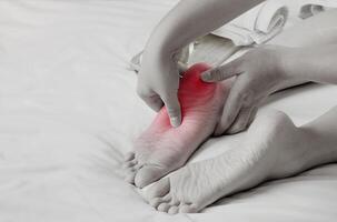 pé dor, massagista mãos cobrir mulher pés com ervas óleo em cama para relaxar músculos a partir de solas do pés. saúde Cuidado e pé remédio foto