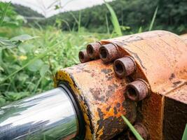 peneumático cilindro em uma ampla motor, visível oxidado parafusos foto