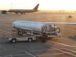 aviação combustível caminhão às aeroporto terminal com aeronave foto