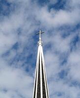 cristão Cruz no topo do Igreja campanário com nuvens foto