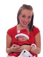 infantil bebê sentado em da mãe colo vestindo Natal equipamento foto
