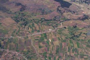 aéreo tiro do agrícola Campos e pequeno Vila ao longo estrada foto