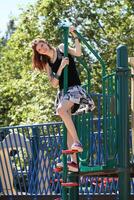 jovem adolescente caucasiano menina escalada Parque infantil equipamento foto