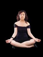 jovem ásia mulher meditando pose Preto equipamento foto