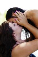 caucasiano e ásia americano mulheres se beijando ao ar livre foto