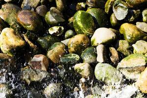 água espirrando em musgo coberto rio pedras foto