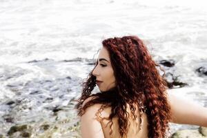 perfil a partir de costas hispânico mulher às oceano foto