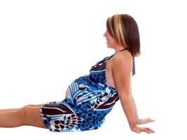 jovem grávida mulher em chão dentro azul e branco vestir foto