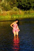 japonês americano mulher em pé dentro rio vestir foto