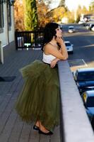 atraente latina mulher em pé em sacada olhando Fora foto