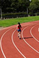 jovem hispânico adolescente mulher corrida em rastrear costas para Câmera foto