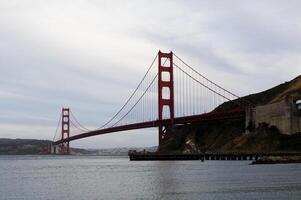 dourado portão ponte a partir de Marin com nublado céu foto