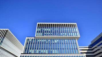 moderno escritório construção dentro a cidade com janelas e aço e alumínio painéis muro. contemporâneo comercial arquitetura, vertical convergindo geométrico linhas. foto