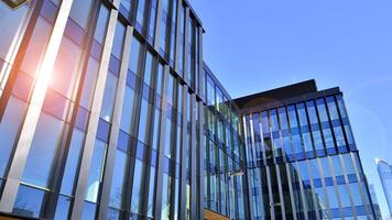 moderno escritório construção com vidro fachada. transparente vidro parede do escritório prédio. reflexão do a azul céu em a fachada do a prédio. foto