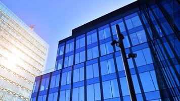 moderno escritório construção com vidro fachada. transparente vidro parede do escritório prédio. reflexão do a azul céu em a fachada do a prédio. foto