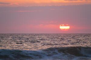 oceano ondas em pôr do sol fundo foto