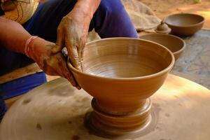 cerâmica especializado molhado mãos do oleiro modelar a argila em oleiro roda foto
