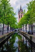 delt canal com bicicletas e carros estacionado junto. Delft, Países Baixos foto