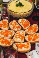 caseiro festivo almoço com sanduíches, vermelho caviar, e manteiga em mesa foto