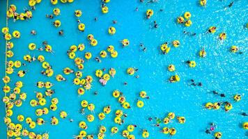 topo Visão do pessoas relaxante dentro a piscina em amarelo inflável círculos foto