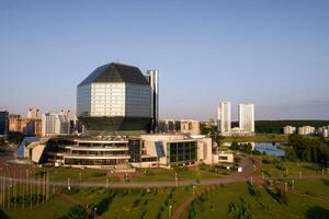 topo Visão do a nacional biblioteca e uma Novo Vizinhança com uma parque dentro minsk-o capital do a república do bielorrússia às pôr do sol, uma público construção foto