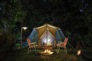 vintage cabine barraca, Antiguidade óleo lâmpada, retro cadeiras, grupo do acampamento tendas com ao ar livre fazer café instalações em de madeira mesas dentro uma floresta acampamento área dentro a floresta. foto