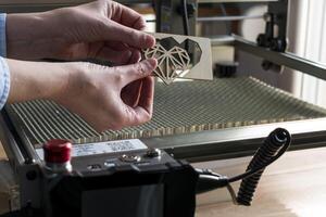 laser gravação e corte, mulher segurando a exemplo do uma cortar Fora de madeira coração foto