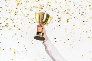 ai gerado mãos do o negócio mulher segurando e lift uma dourado troféu, em torno da com Parabéns confete fita flocos. foto