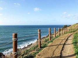 trilha com postes de madeira perto do mar. Ilha de Jeju, Coreia do Sul foto