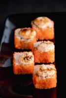 rolos de sushi com caviar na chapa preta. servindo comida japonesa foto