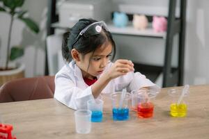 ásia menina fazendo químico experimentos às a laboratório foto