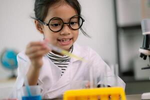 ásia criança menina Aprendendo Ciência química com teste tubo fazer experimentar às escola laboratório. Educação, Ciência, química, e crianças conceitos. cedo desenvolvimento do crianças. foto