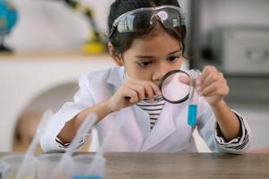 ásia criança menina Aprendendo Ciência química com teste tubo fazer experimentar às escola laboratório. Educação, Ciência, química, e crianças conceitos. cedo desenvolvimento do crianças. foto