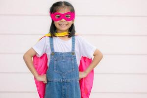 uma engraçado pequeno menina vestindo uma Super heroi fantasia. Super heroi conceito. foto