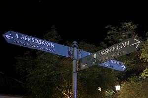 estrada placa com texto em Jalan pasar tragaharjo às noite, Yogyakarta, Indonésia foto