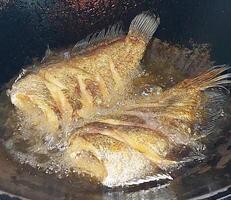 seco salgado gourami, profundo frito peixe em frigideira. topo Visão imagem. foto