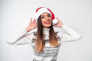 fechar acima retrato lindo caucasiano mulher dentro vermelho santa chapéu em branco estúdio fundo. Natal e Novo ano feriado conceito. foto