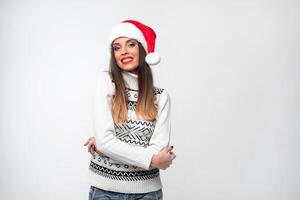 fechar acima retrato lindo caucasiano mulher dentro vermelho santa chapéu em branco estúdio fundo. Natal e Novo ano feriado conceito. foto