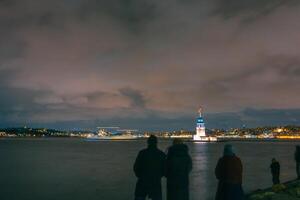 kiz kulesi ou donzela torre às noite com silhueta do pessoas. foto