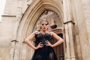 uma à moda noiva dentro uma Preto Casamento vestir poses dentro a antigo francês cidade do Avinhão. modelo dentro uma lindo Preto vestir. foto tiro dentro provence.