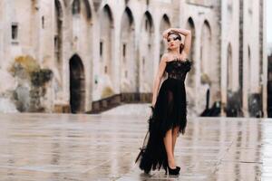 uma à moda noiva dentro uma Preto Casamento vestir poses dentro a antigo francês cidade do Avinhão. modelo dentro uma lindo Preto vestir. foto tiro dentro provence.