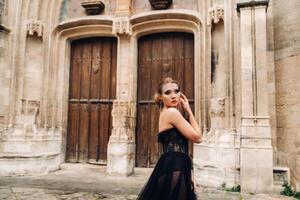 uma à moda noiva dentro uma Preto Casamento vestir poses dentro a antigo francês cidade do Avinhão. modelo dentro uma lindo Preto vestir. foto tiro dentro provence.